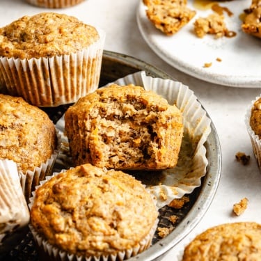 apple, banana & carrot muffins on a plate with a bite taken out