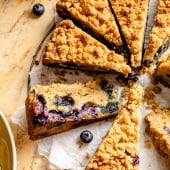 blueberry coffee cake cut into slices on parchment paper