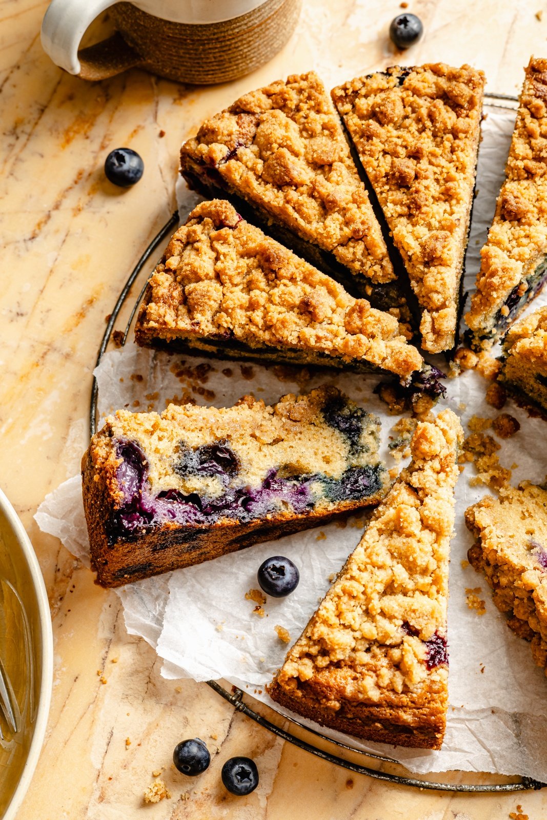 blueberry coffee cake sliced on parchment paper