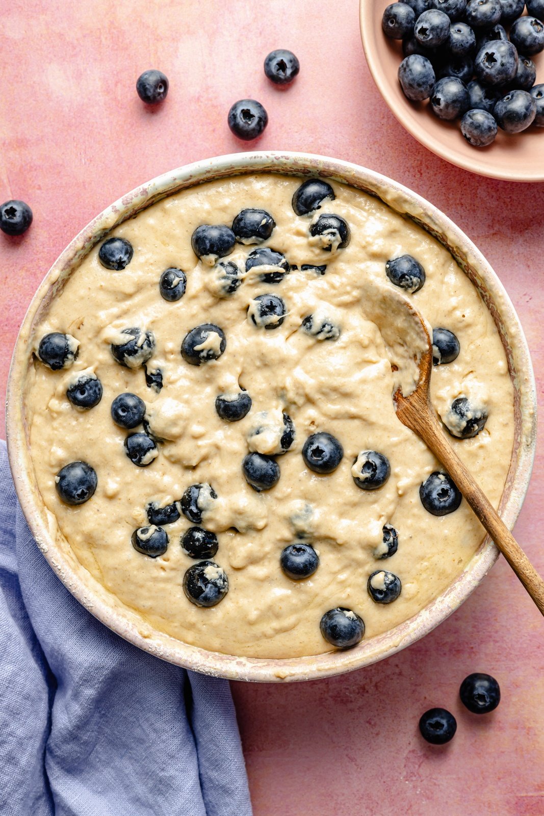 stirring blueberries into breakfast cake batter