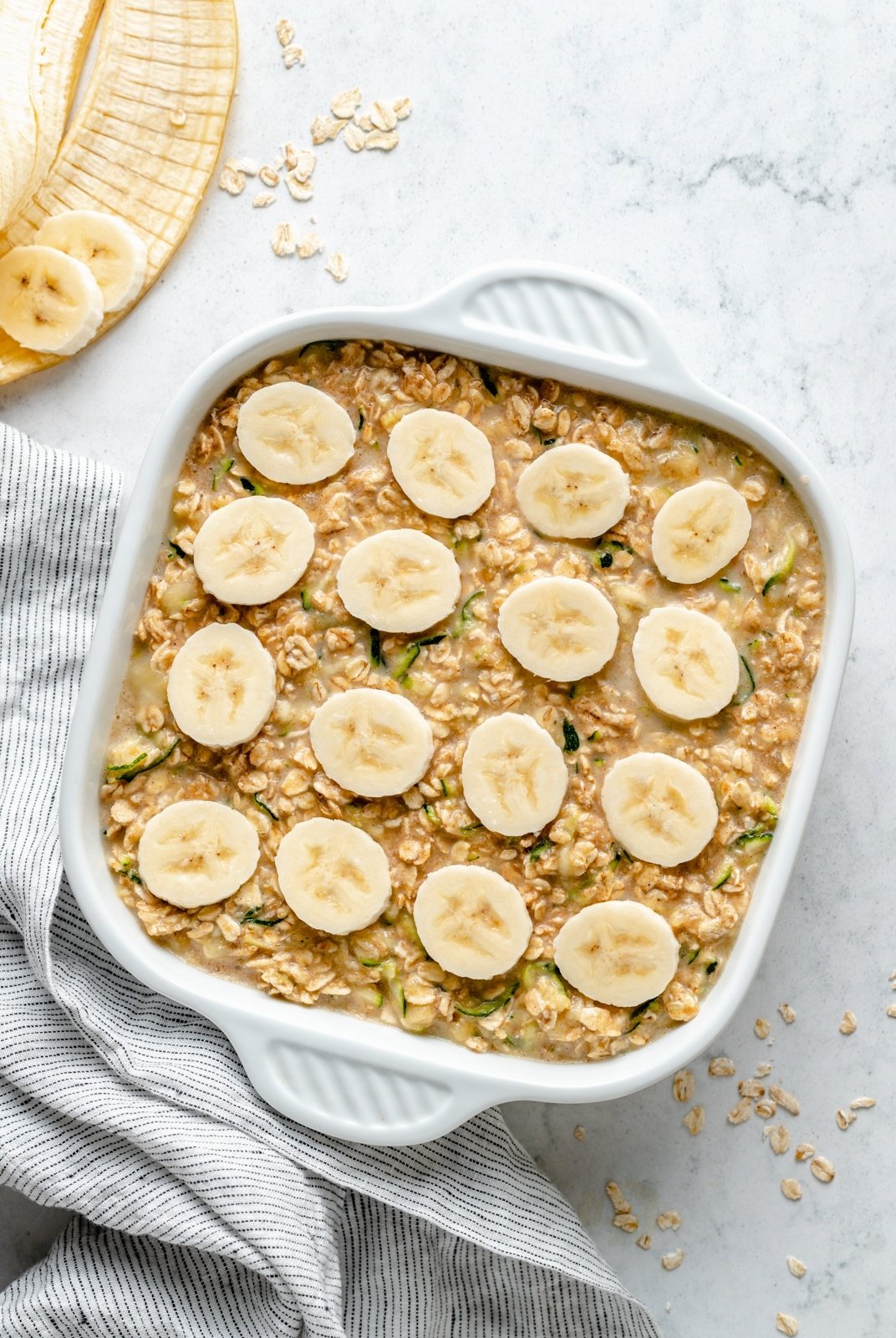 unbaked zucchini banana oatmeal bake topped with bananas