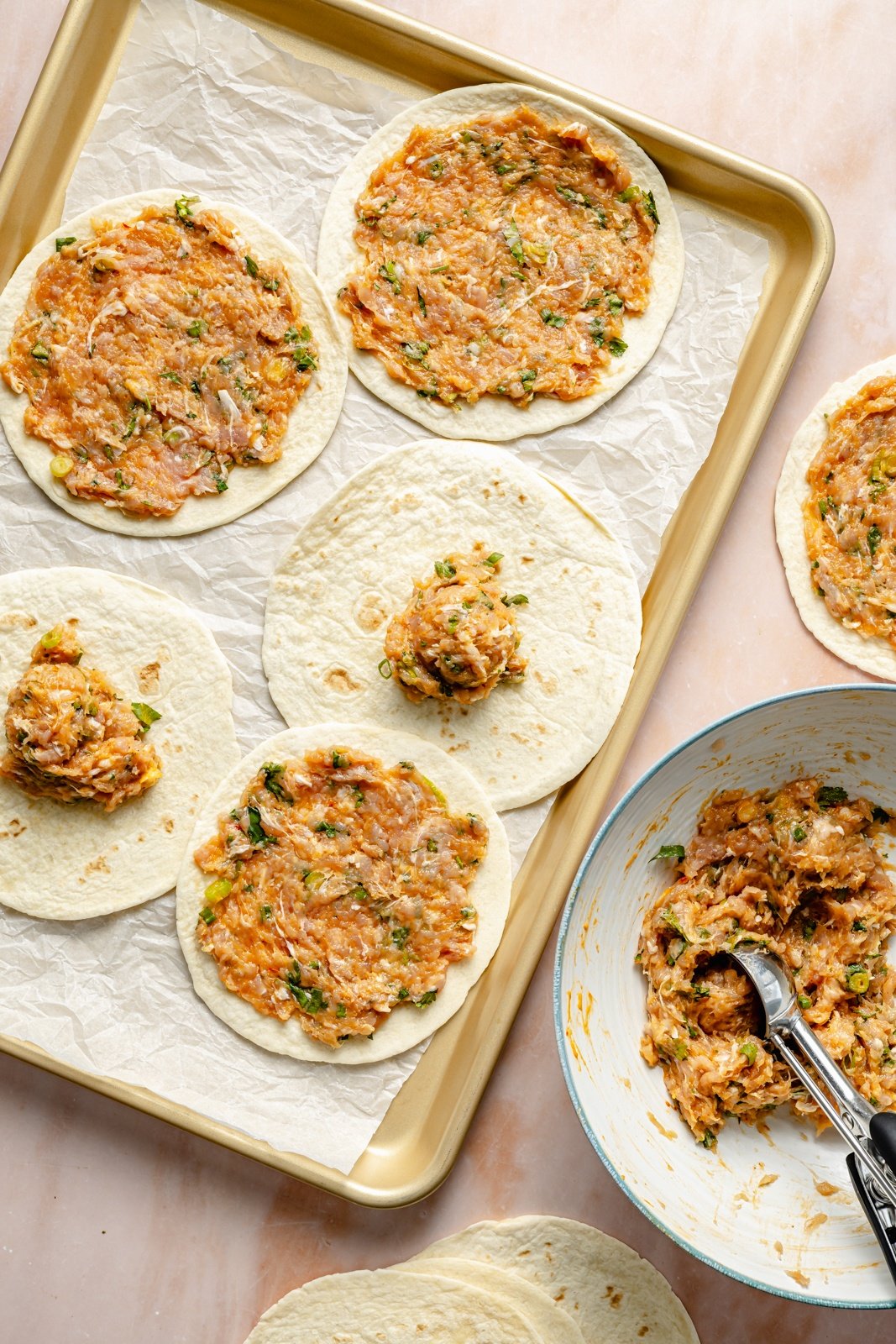 adding chicken to tortillas to make smashed buffalo chicken tacos