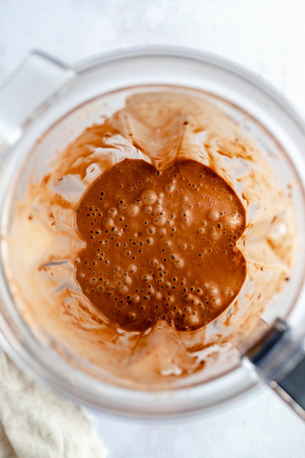 top-down view of a chocolate peanut butter banana smoothie in a blender