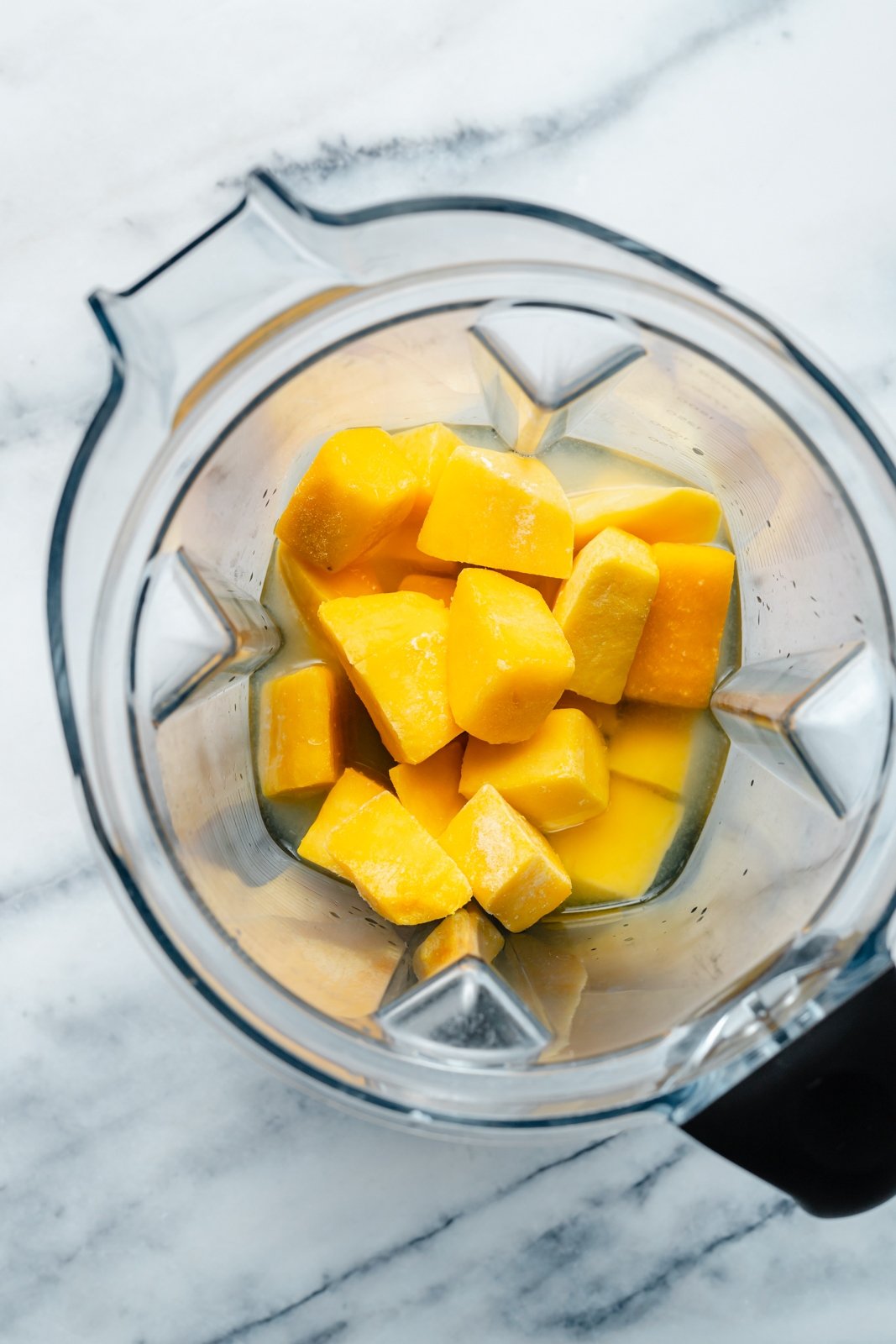 ingredients for an easy frozen mango margarita in a blender