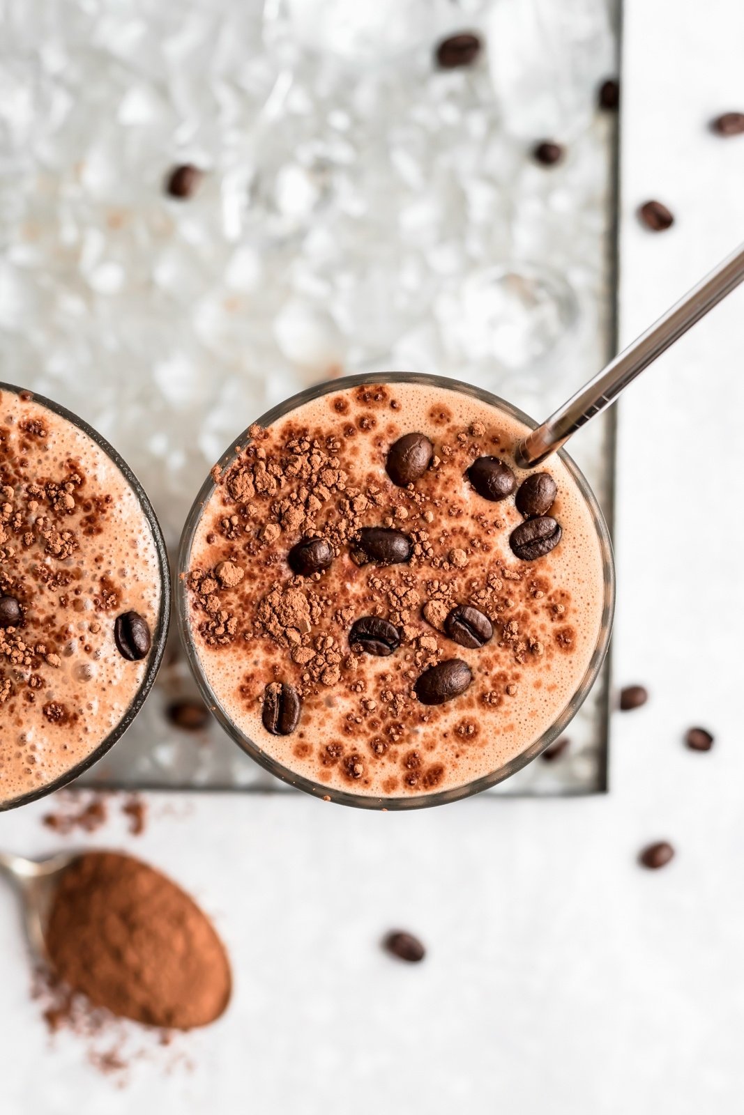 top of a coffee smoothie topped with cacao powder and espresso beans