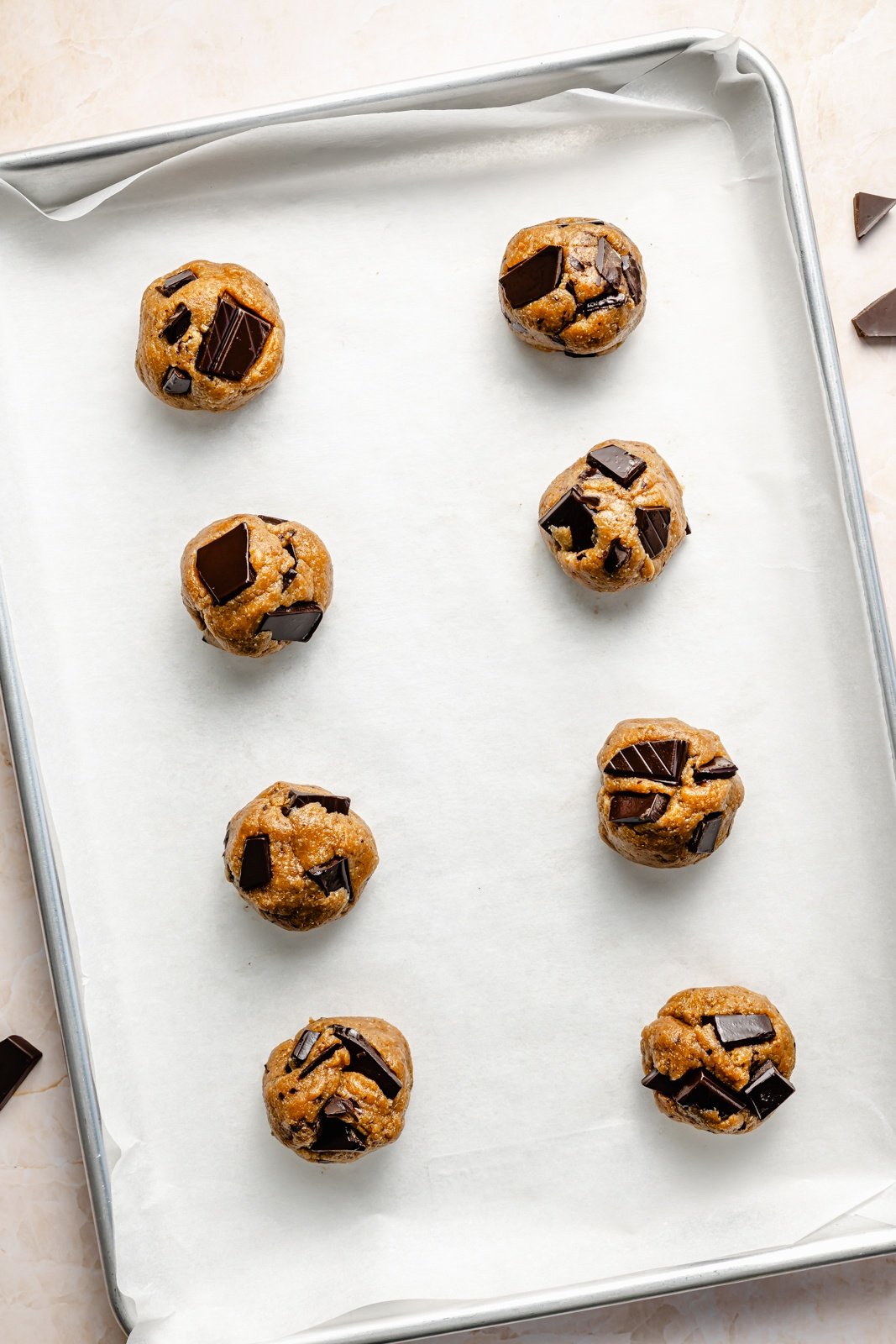 unbaked healthy peanut butter chocolate chunk cookies on a baking sheet