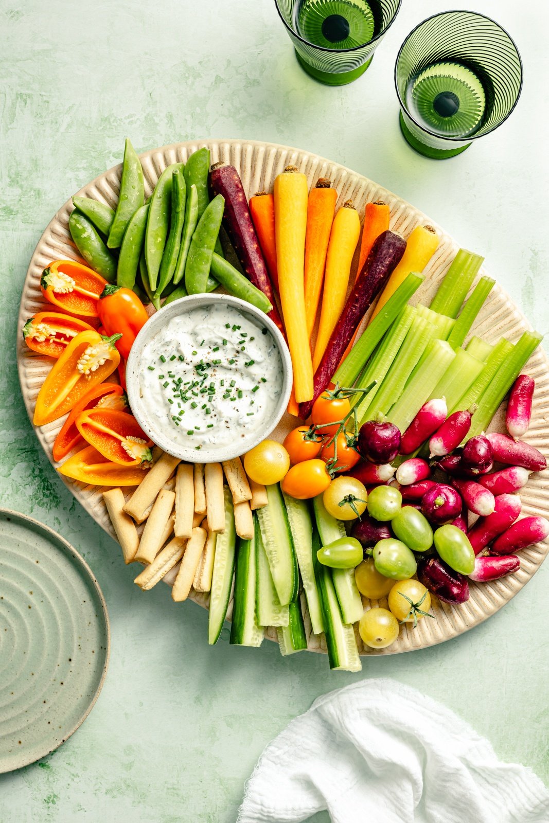 greek yogurt ranch dressing in a bowl on a platter of veggies