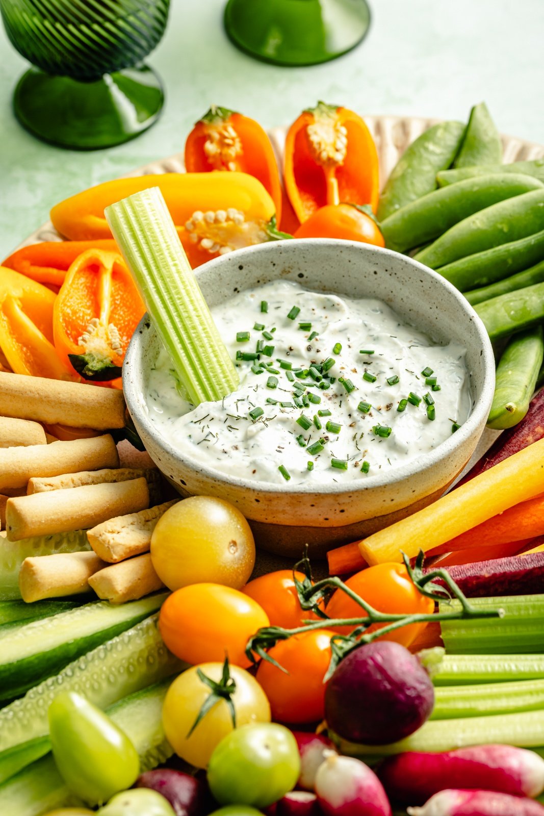 healthy ranch dressing on a platter of veggies with a celery stick dipped into it
