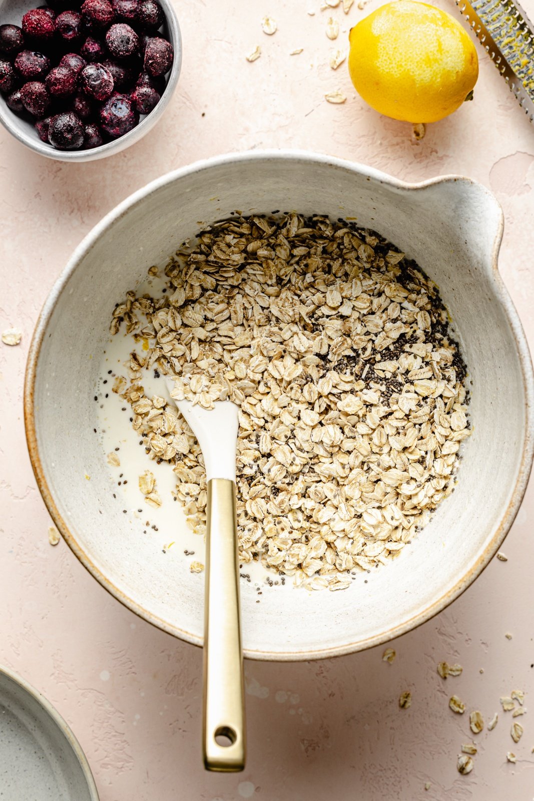 mixing oats into a bowl to make lemon blueberry overnight oats