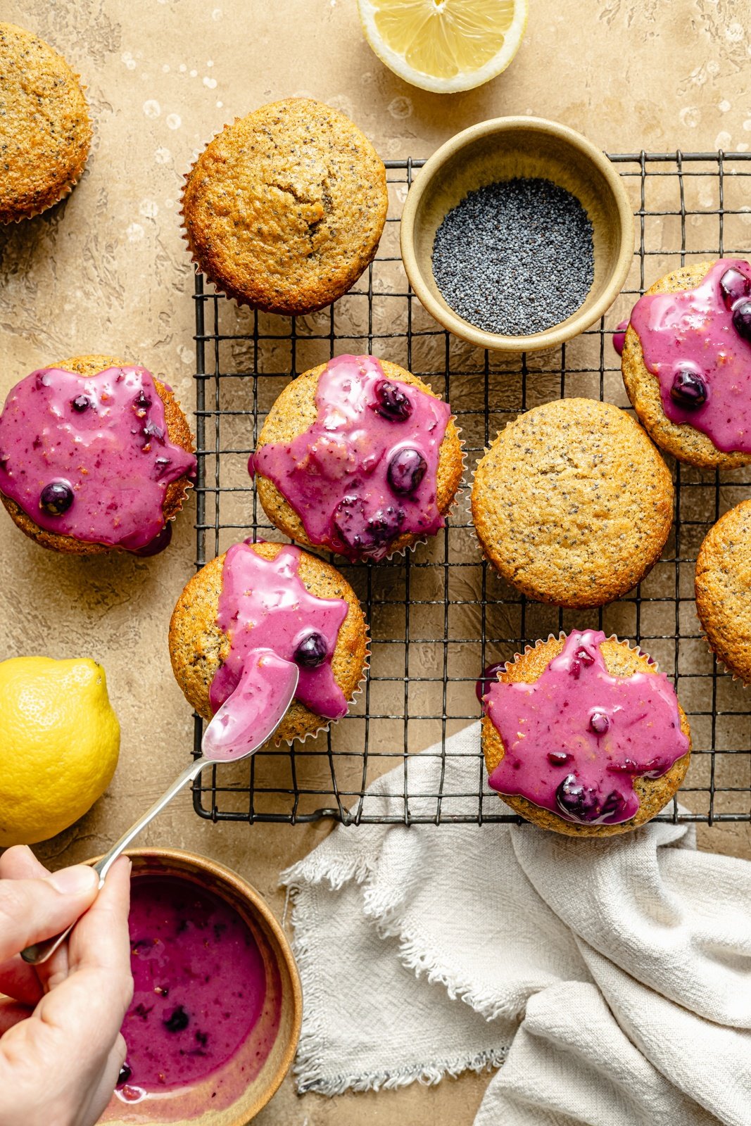adding a blueberry glaze to healthy lemon poppy seed muffins