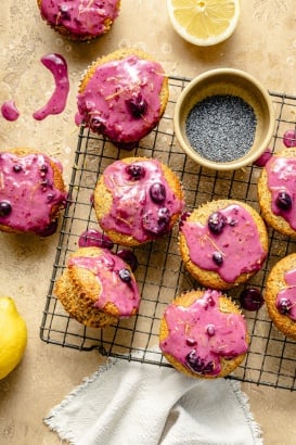 healthy lemon poppy seed muffins with blueberry glaze on a wire rack
