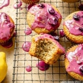 healthy lemon poppy seed muffins with blueberry glaze on a wire rack