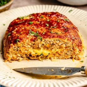 veggie-packed chicken meatloaf stuffed with cheese and sliced on a plate