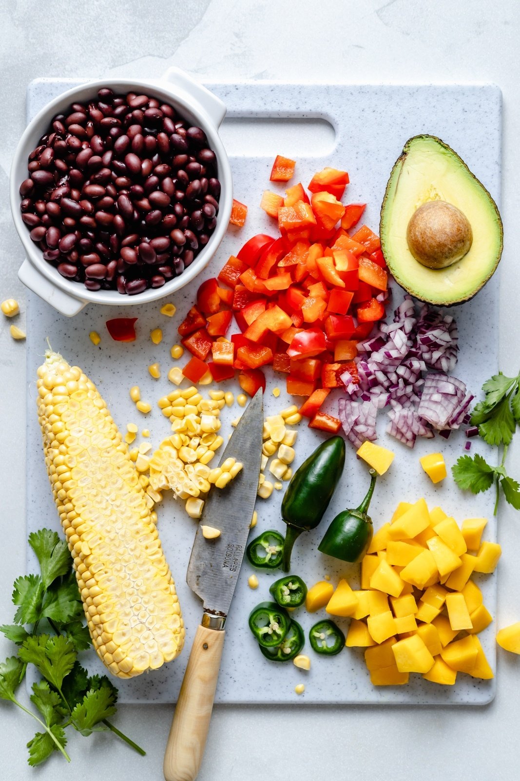 ingredients for a green rice burrito bowl on a cutting board