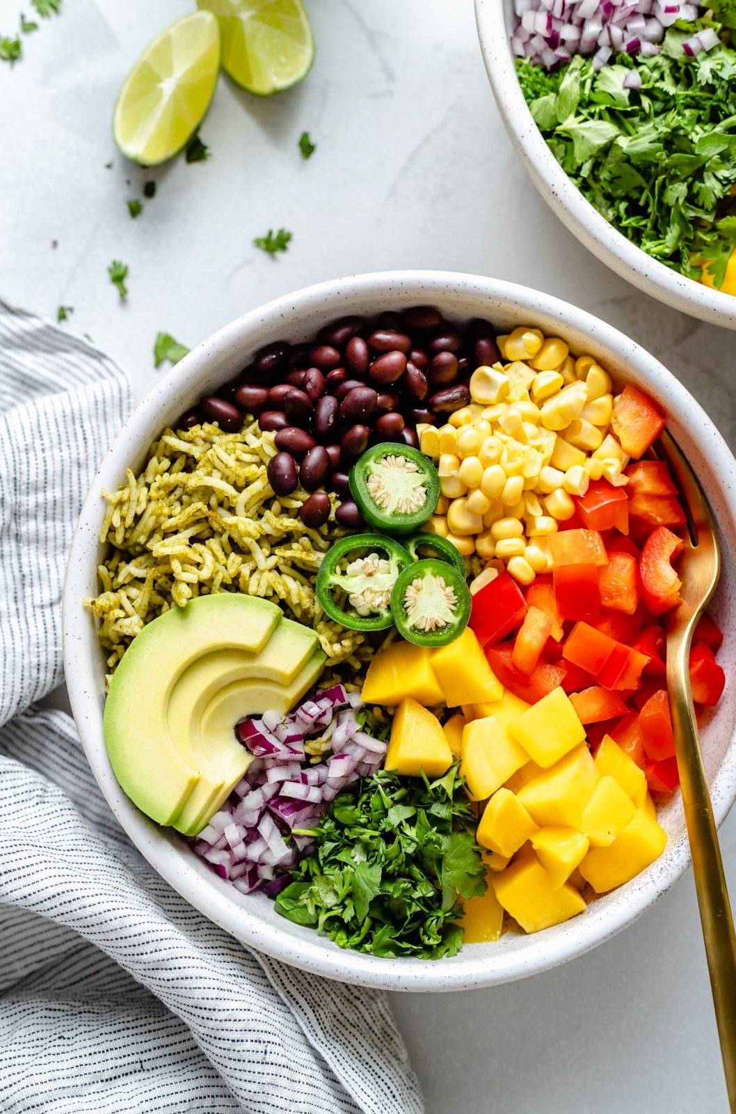 green rice bowl with mango, avocado, corn, bell pepper and black beans