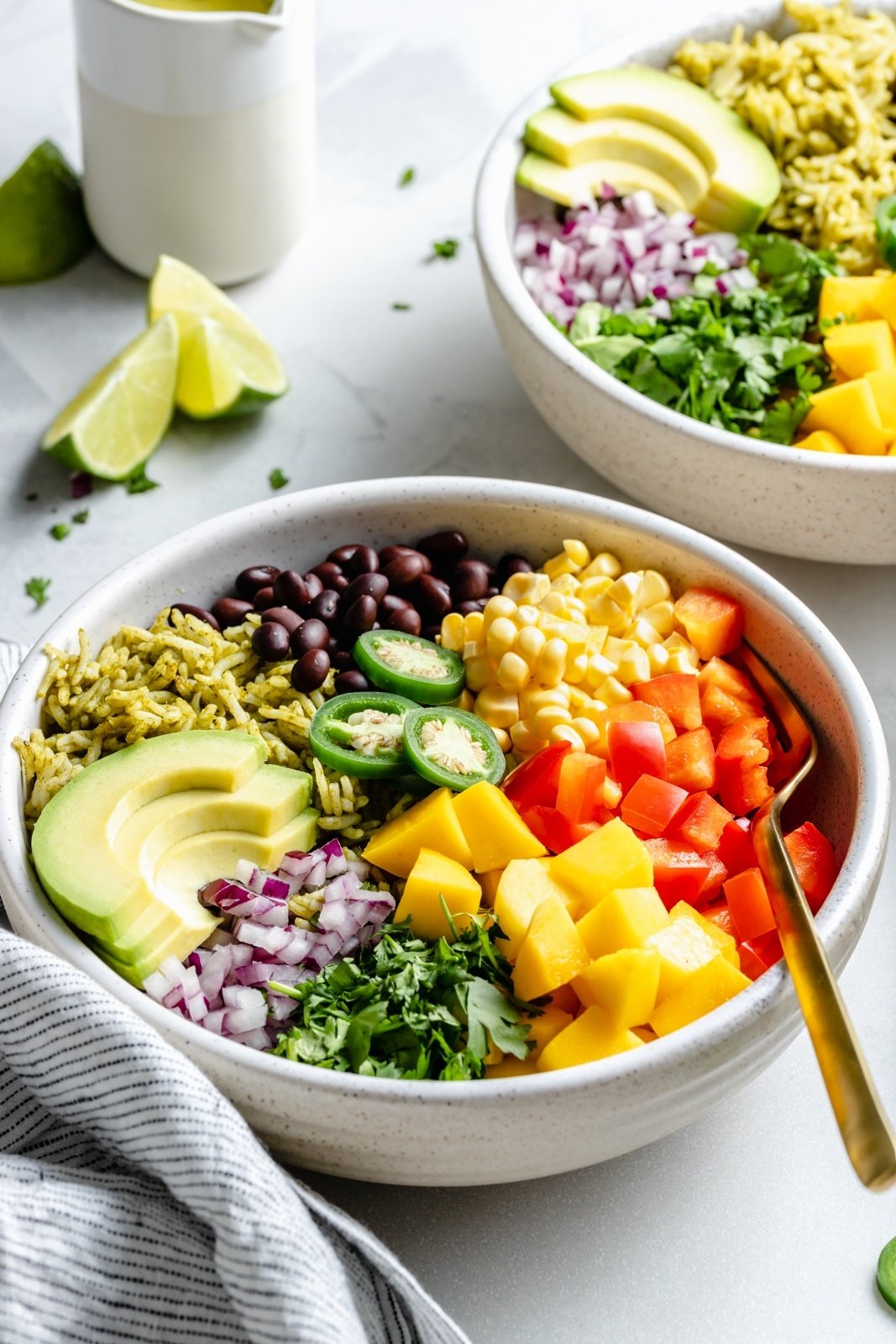 vegetarian green rice bowls topped with veggies and mango