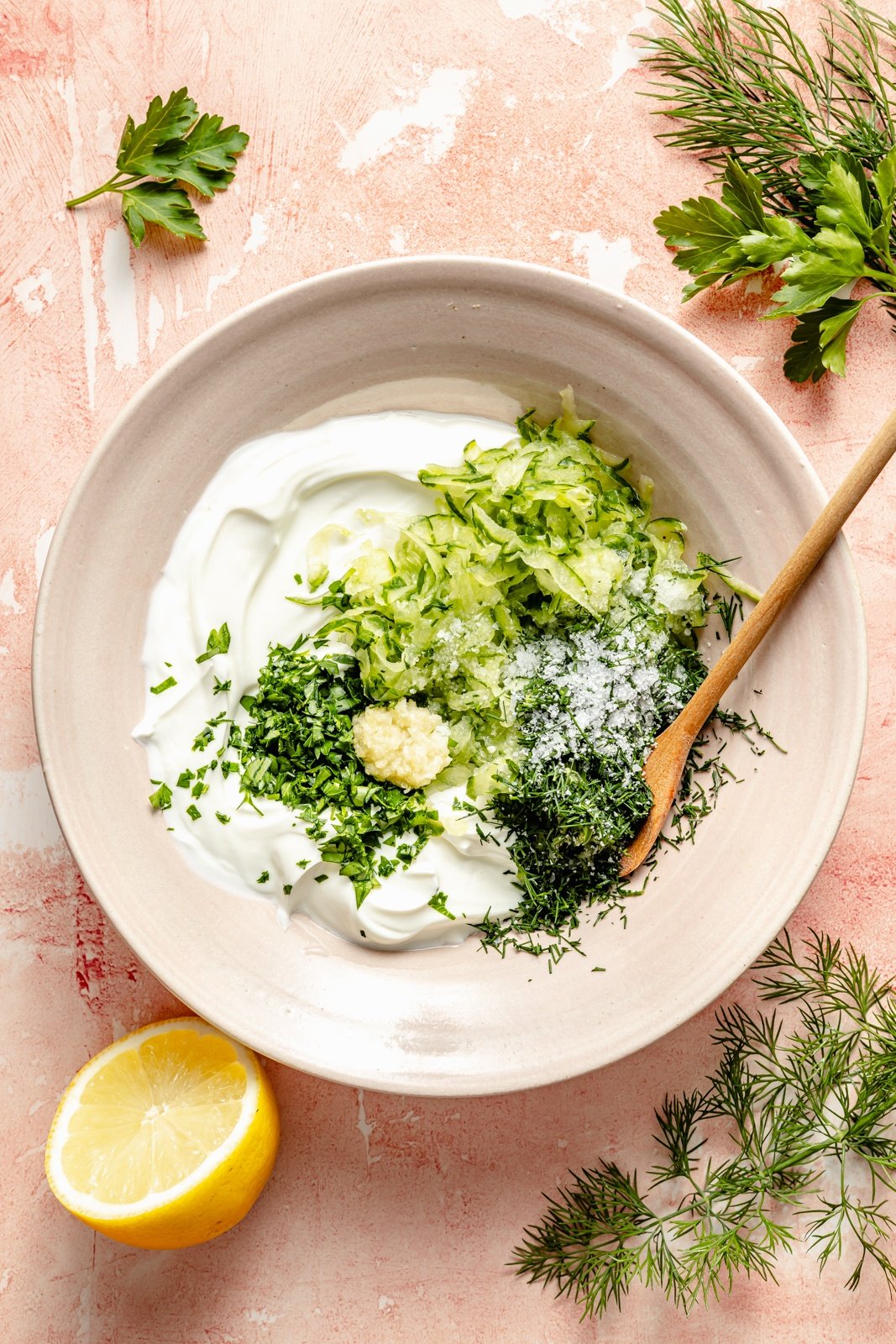 mixing tzatziki sauce in a bowl for mediterranean chicken