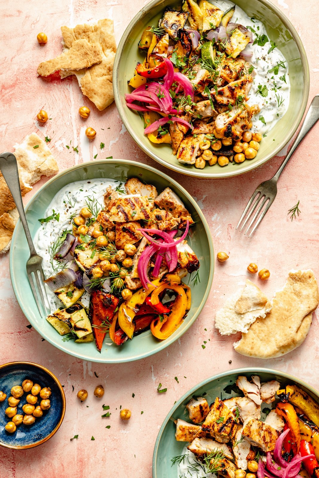 grilled mediterranean chicken in bowls with vegetables, chickpeas, and tzatziki sauce