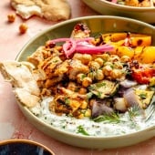 grilled mediterranean chicken and vegetables in a bowl with tzatziki sauce