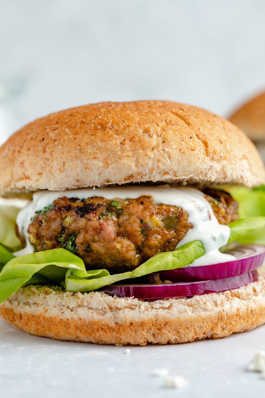 moroccan turkey burger with feta sauce, lettuce and red onion