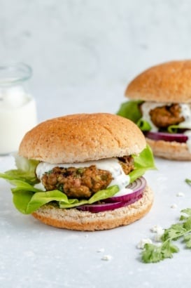 moroccan-inspired turkey burger topped with feta sauce, lettuce and red onion