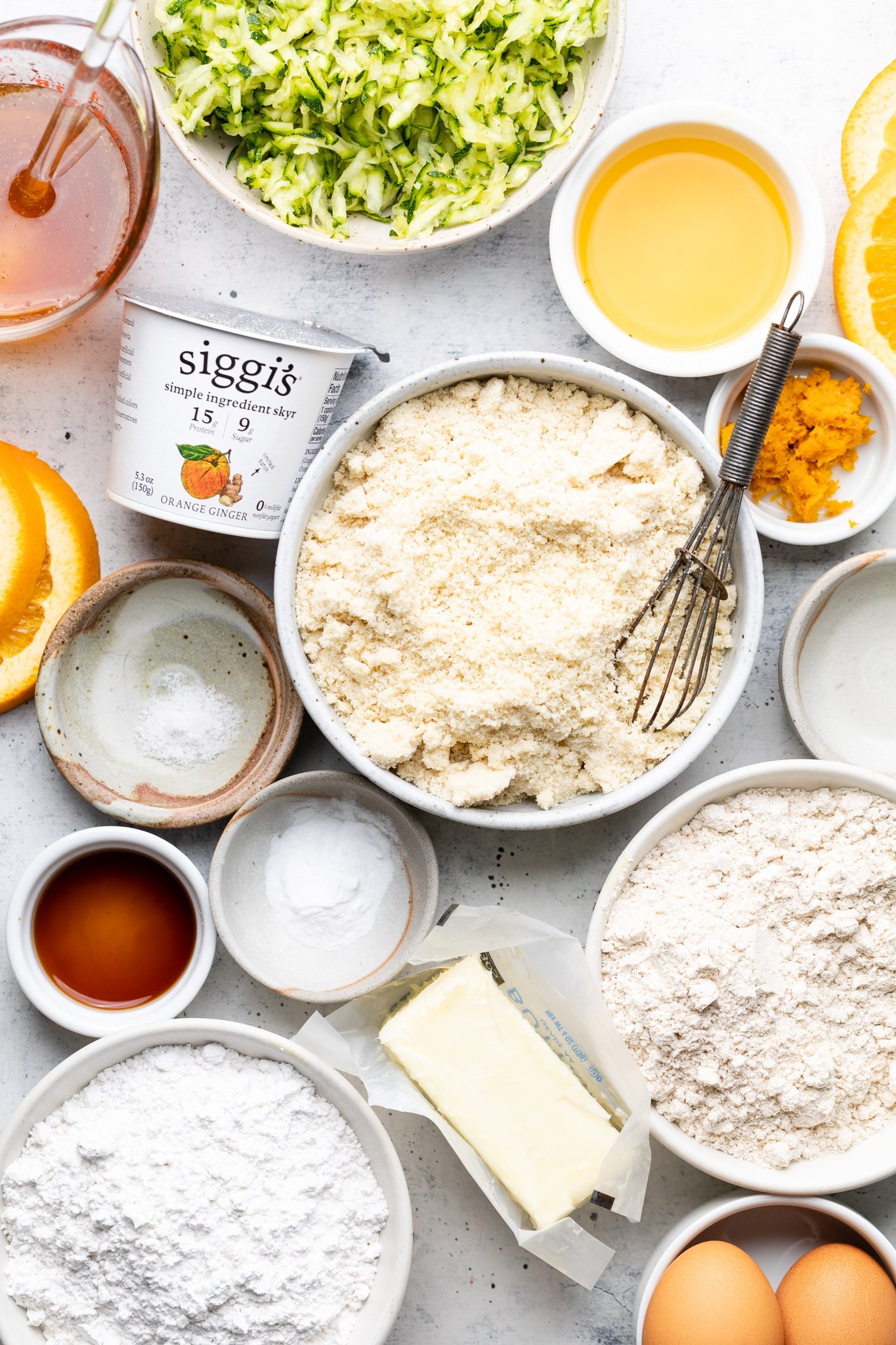 ingredients for an orange zucchini cake on a board
