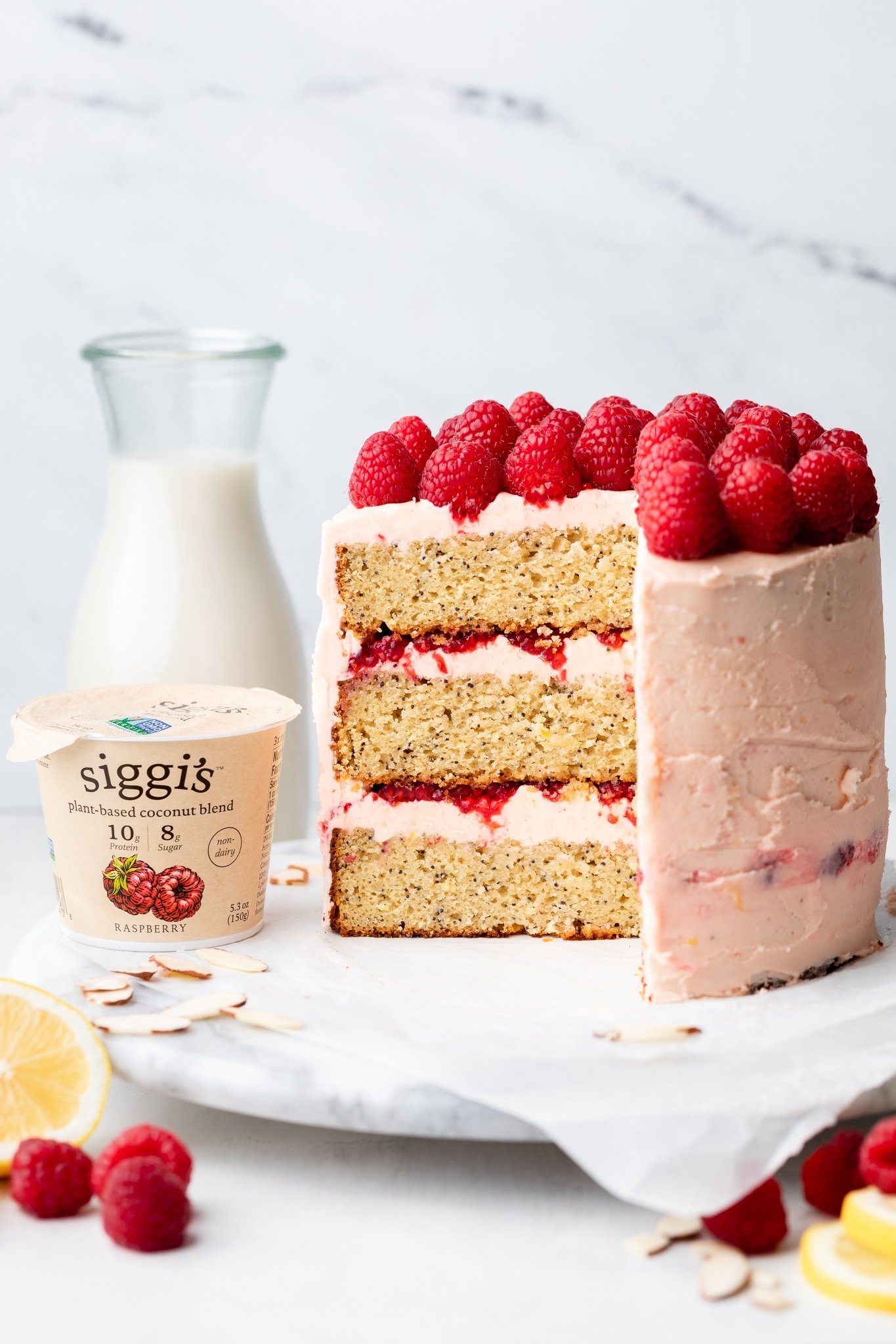 gluten free lemon raspberry cake next to a container of yogurt