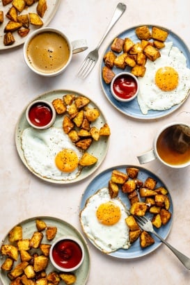 plates with roasted breakfast potatoes, eggs, and ketchup