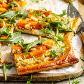 drizzling hot honey onto slices of a roasted carrot tart