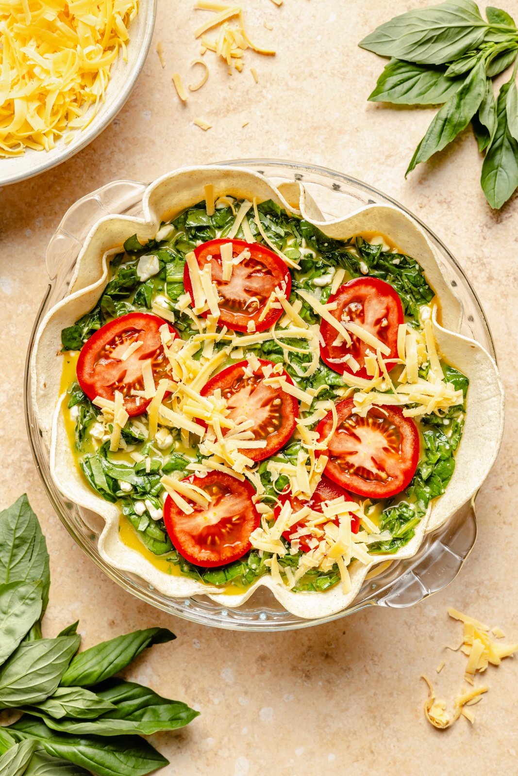 unbaked tomato basil tortilla quiche in a pie pan