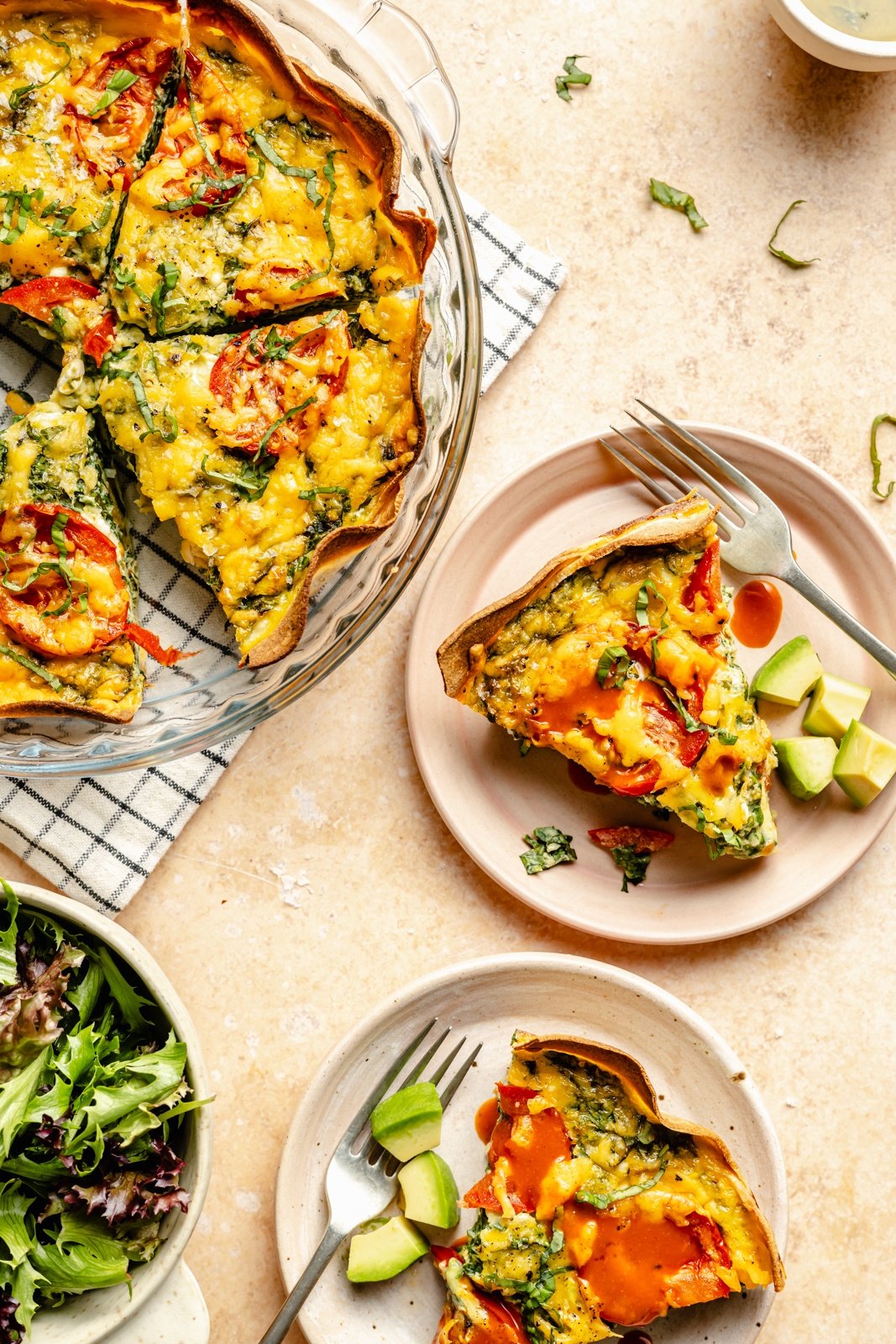 slices of tortilla quiche in a pie pan and on plates topped with hot sauce
