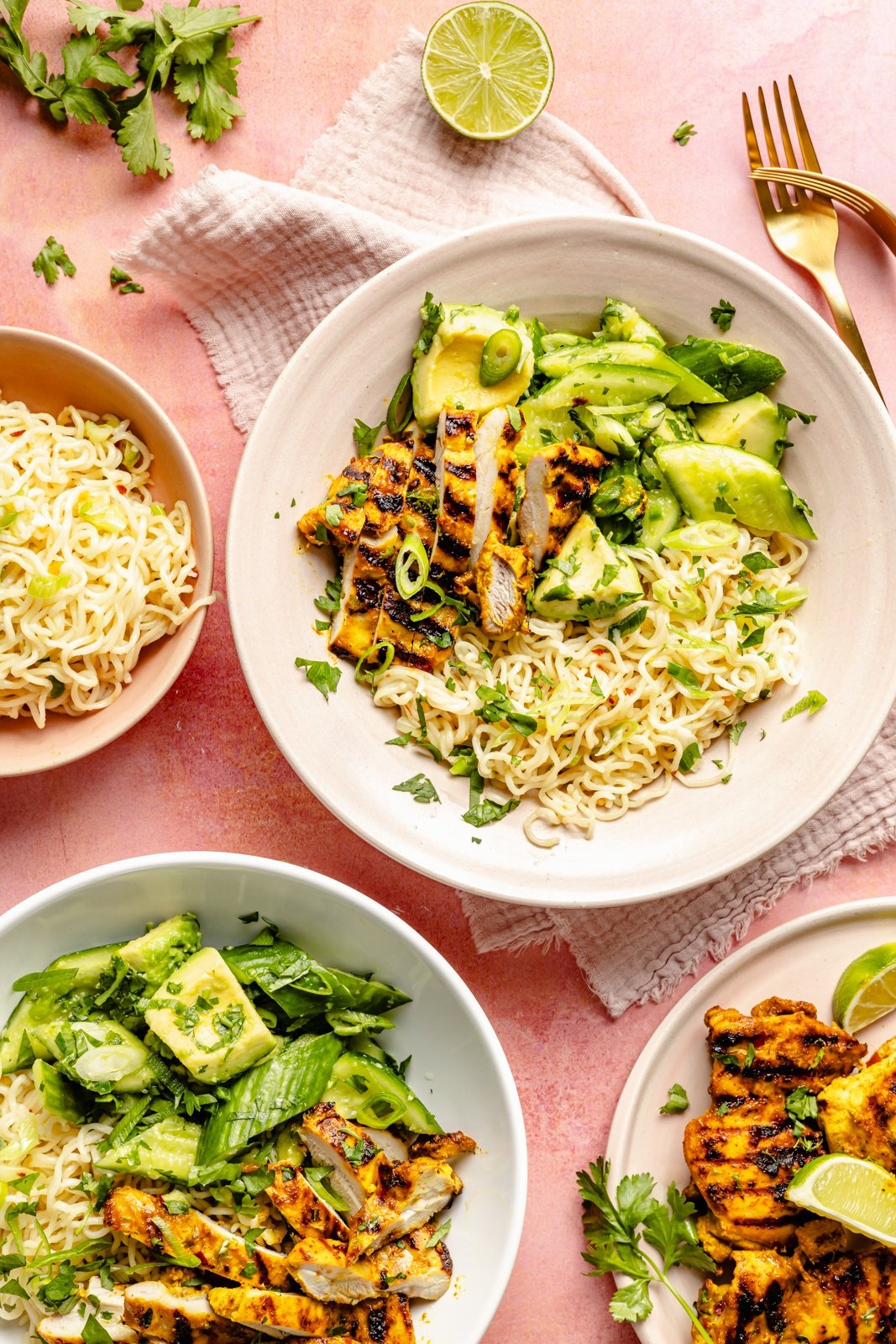 grilled turmeric chicken bowls next to a bowl of ramen noodles and plate of chicken