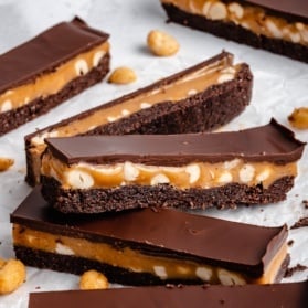egg-free chocolate peanut butter caramel bars on parchment paper